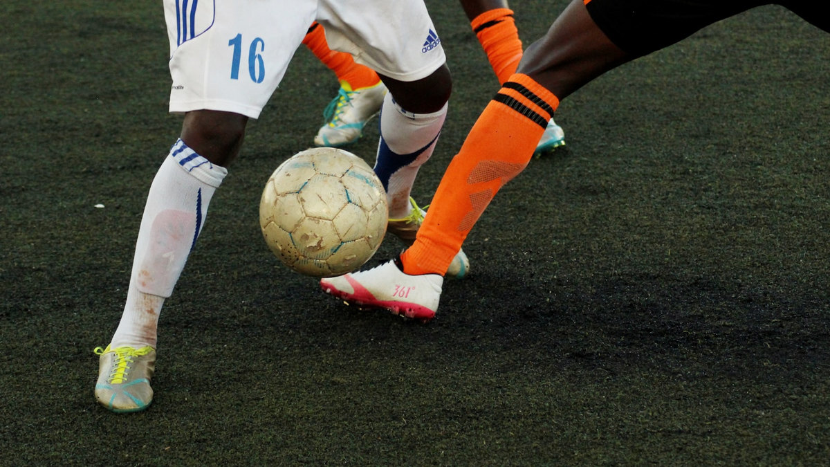 Joueurs de football en action sur un terrain de stade Joueurs de football en action sur un terrain de stade