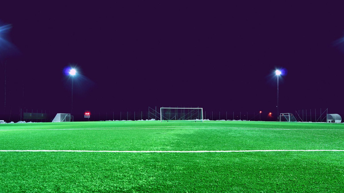 Stade de football vide la nuit, pelouse éclairée Stade de football vide la nuit, pelouse éclairée
