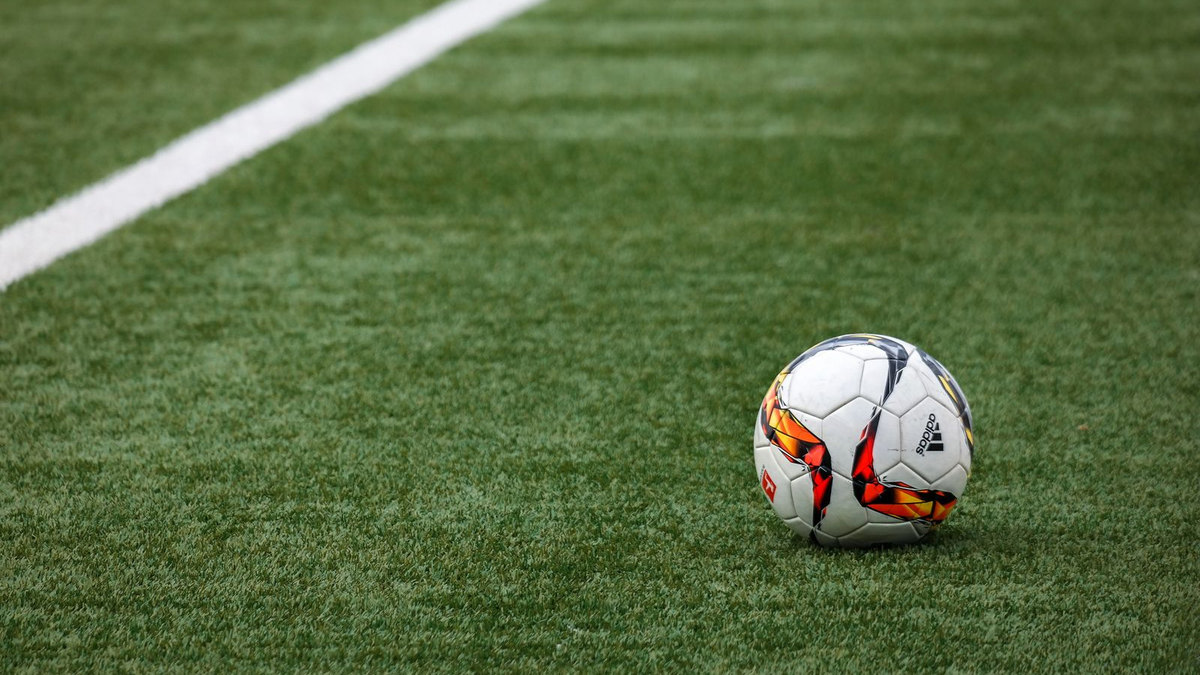 Match de football en cours sous les projecteurs d’un stade Match de football en cours sous les projecteurs d’un stade