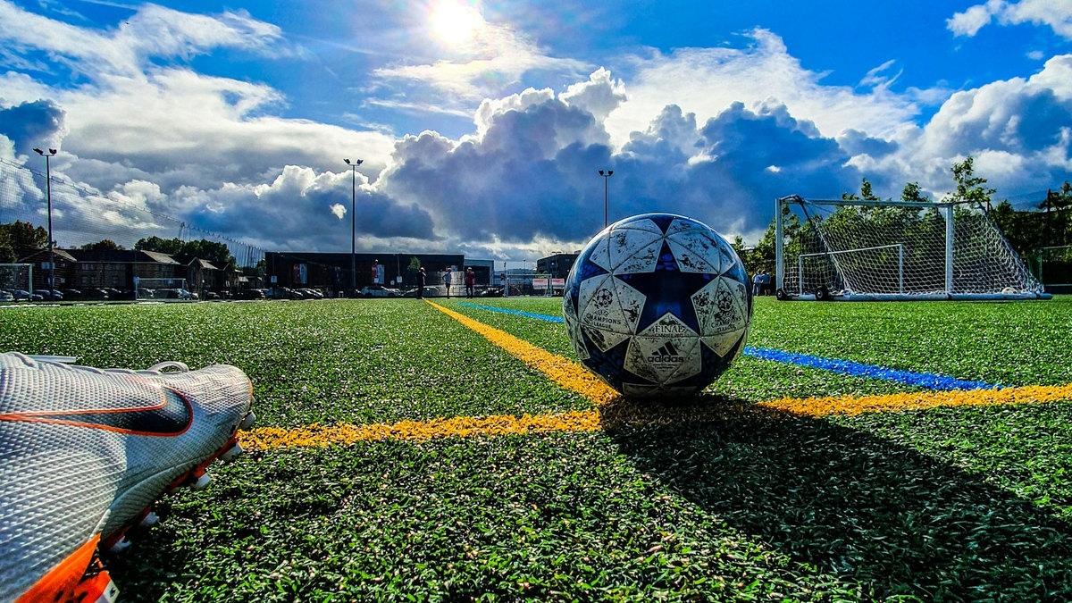 Attaquant en pleine frappe au but sur un terrain de football Attaquant en pleine frappe au but sur un terrain de football